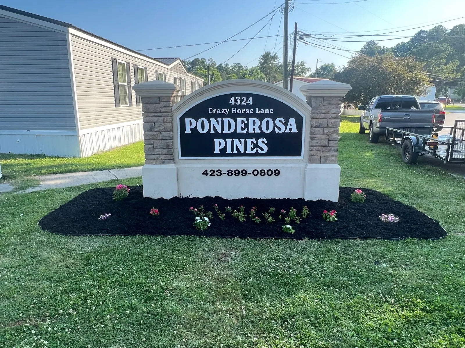 Freshly mulched flower bed around a community entrance sign
