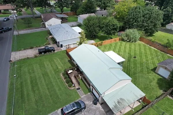 Aerial view of a mowed residential property, front and back yards both striped